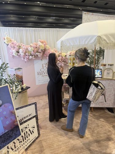 Canada's Bridal Show October 2026 - Elevated Events booth with a pink floral arch and fringed umbrella