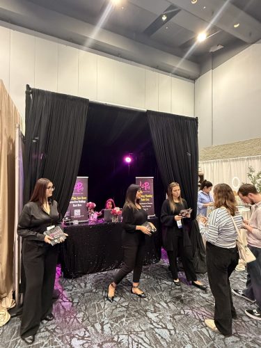 Canada's Bridal Show October 2026 - Exhibitor team welcoming visitors at a black-draped booth